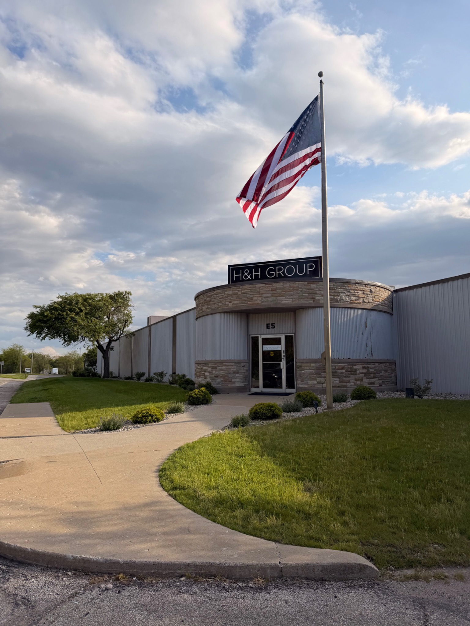 H&H Group building entrance and American flag